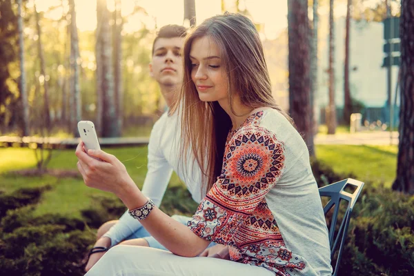 Hermosa pareja en un banco en un parque — Foto de Stock