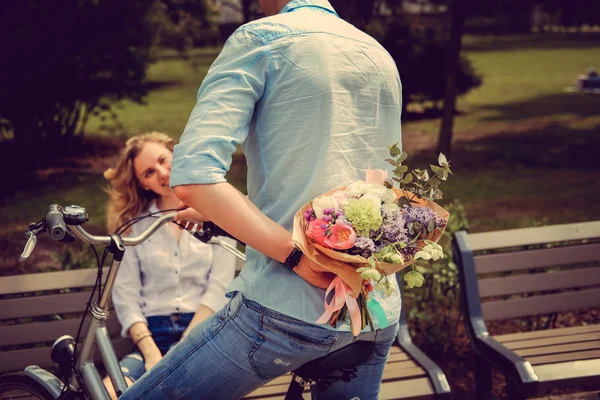 Homem dando flores para mulher loira — Fotografia de Stock