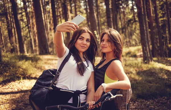 Två kvinnliga med cyklar att göra selfie — Stockfoto