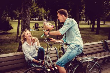 Sarışın kadına çiçek veren adam