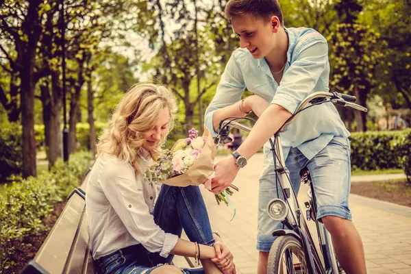 Man die bloemen geeft aan blonde vrouw — Stockfoto