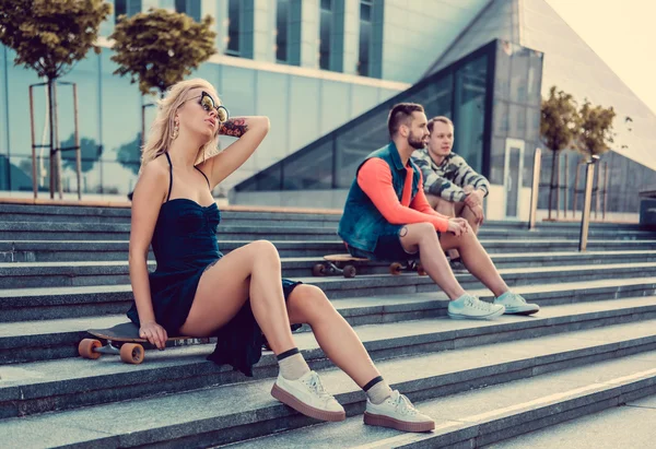 Blond vrouwtje en twee mannetjes met longboards — Stockfoto