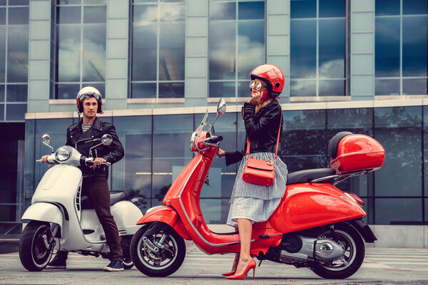 beautiful couple on retro moto scooters