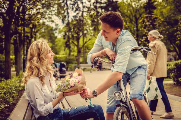 Een man die bloemen geven aan een vrouw. — Stockfoto