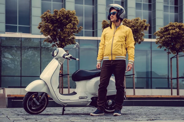 Un hombre en amarillo cerca de scooter blanco —  Fotos de Stock