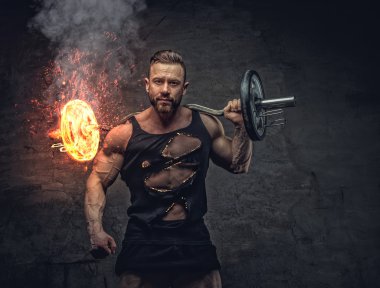 Vücut geliştirmeci yanan halter tutar.