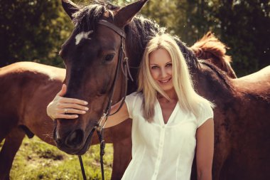 Sarışın kadın kahverengi atlarla poz  