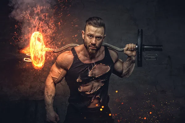 Bodybuilder innehar brinnande skivstång. — Stockfoto