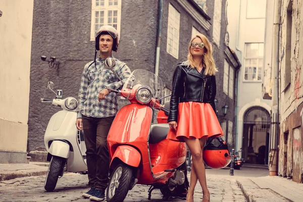 Manliga och kvinnliga på moto skotrar. — Stockfoto