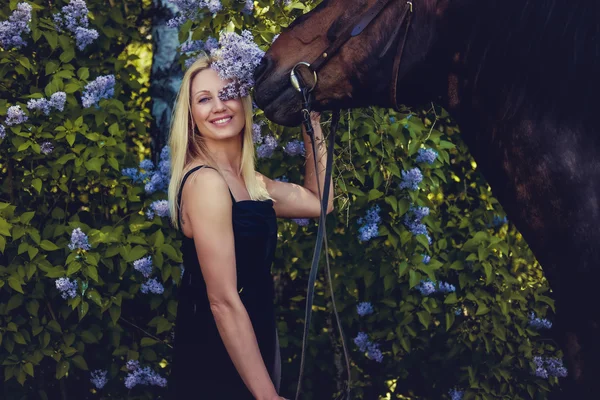 Blond ženy, pózuje s koněm. — Stock fotografie