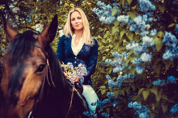 Mujer rubia sentada a caballo . — Foto de Stock