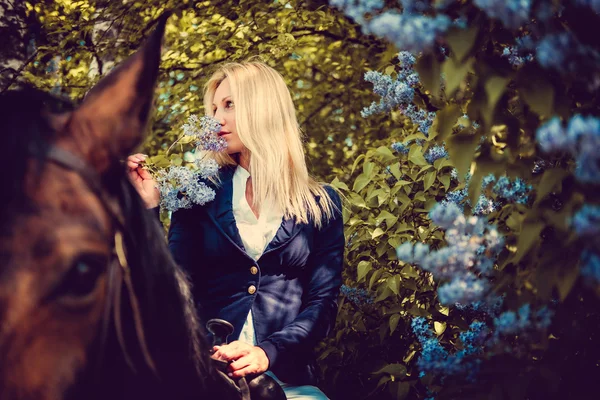 Blondes Weibchen auf Pferderücken. — Stockfoto