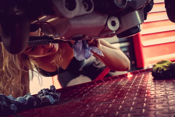 Blond kobieta naprawy motocykla. — Zdjęcie stockowe