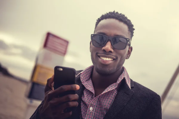 Sonriente afroamericano macho con smartphone —  Fotos de Stock