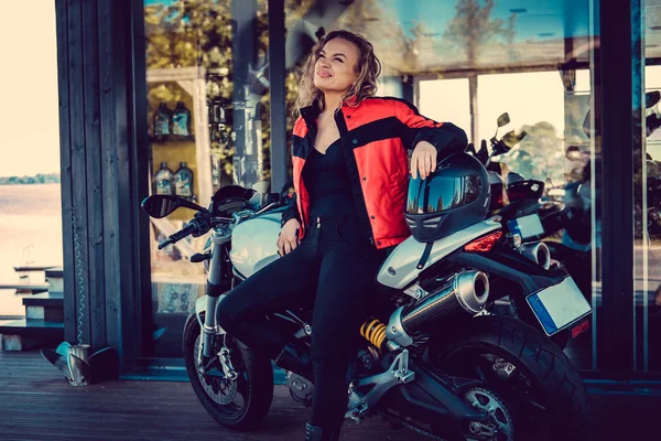 ブロンド女性のオートバイに近いポーズ. — ストック写真