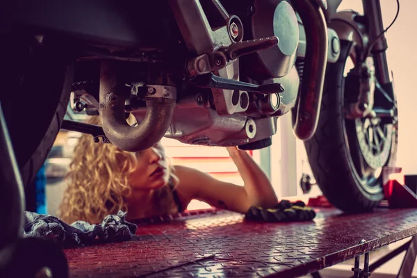 Mujer rubia reparando motocicleta . —  Fotos de Stock