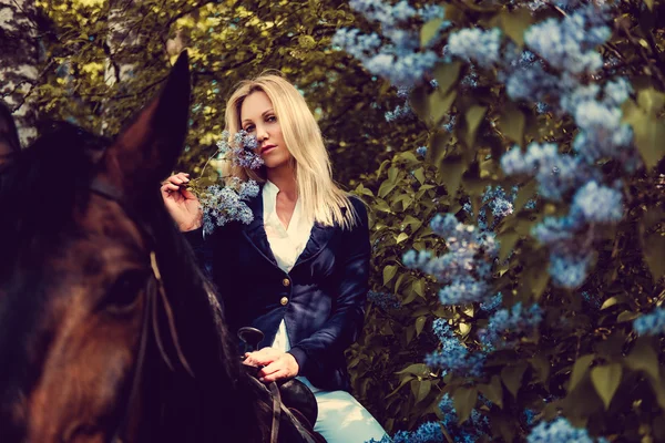 Donna bionda seduta sul dorso del cavallo . — Foto Stock