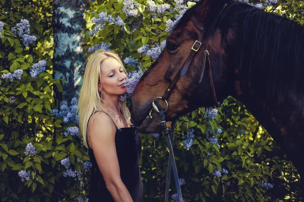 Porträt einer blonden Frau mit Pferd. — Stockfoto