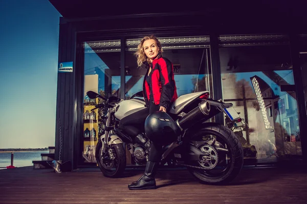 Mulher loira posando perto de moto . — Fotografia de Stock