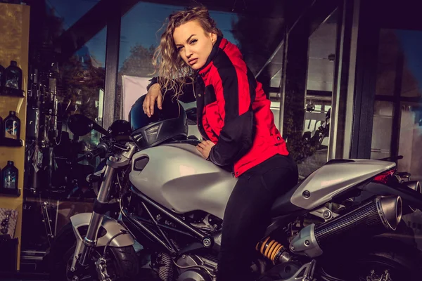 Blondine posiert in der Nähe von Motorrad. — Stockfoto