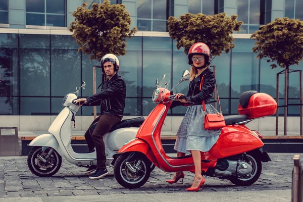 Mannelijke en vrouwelijke op moto scooters. — Stockfoto