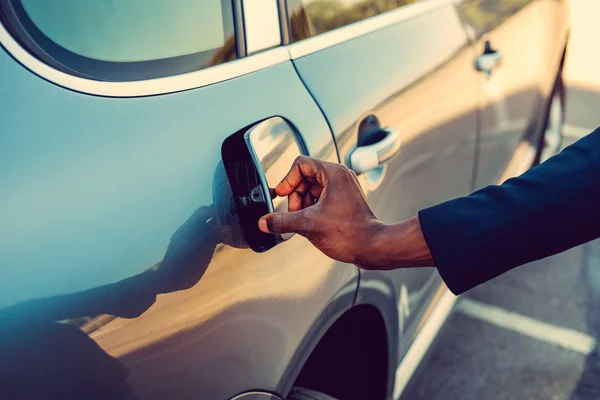 Black man is opening gas tank — Stock Photo, Image