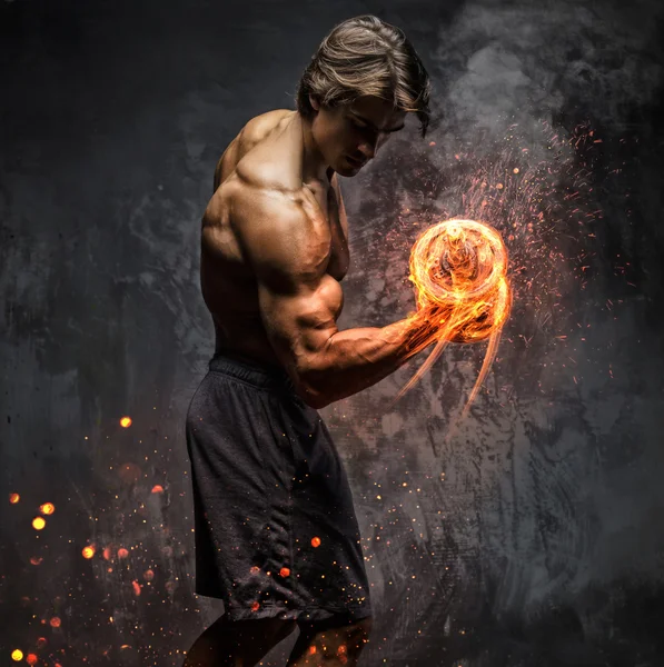 Portrait of a man with burning dumbbell.