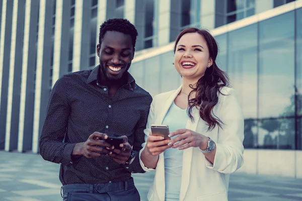 Sorrindo mulher e homem usando smartphones — Fotografia de Stock