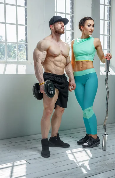 Parrakas kehonrakentaja urheilullisen naisen kanssa — kuvapankkivalokuva