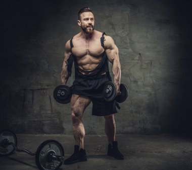 bir stüdyoda dumbbells ile vücut geliştirmeci