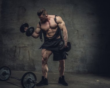 bir stüdyoda dumbbells ile vücut geliştirmeci