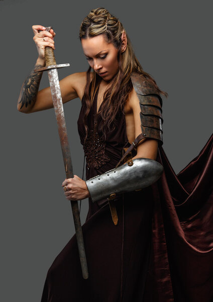 Elf woman warrior with sword on a grey background.