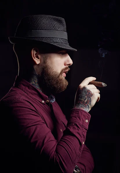 Hombre barbudo fumando un cigarro — Foto de Stock
