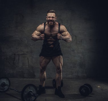 bir stüdyoda dumbbells ile vücut geliştirmeci.