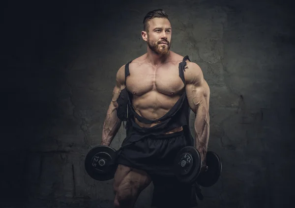 Bodybuilder avec haltères dans un studio — Photo