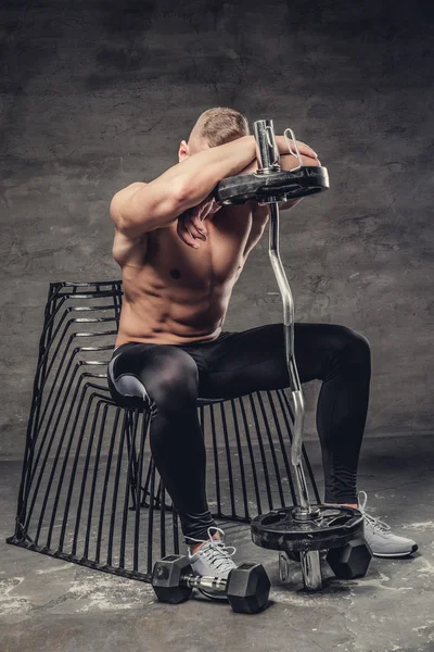 Esportivo macho sentado em uma cadeira — Fotografia de Stock