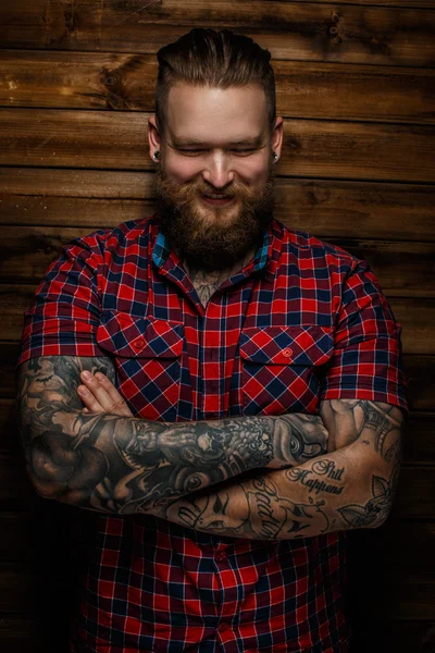 Tatuado barbudo macho em uma camisa vermelha . — Fotografia de Stock