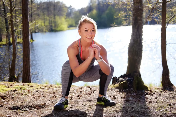 Sporty blond female doing squats — Stock Photo, Image