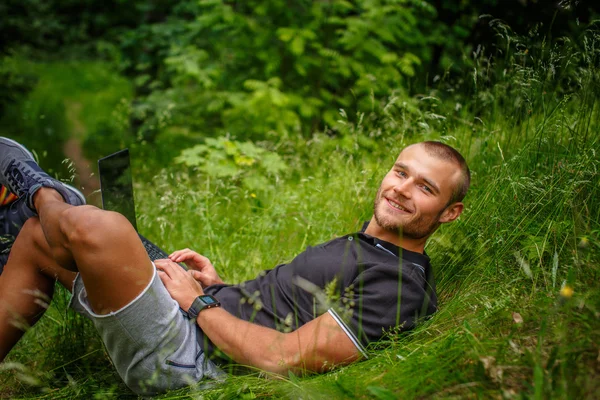 Kavkazská muž ležící trávě — Stock fotografie