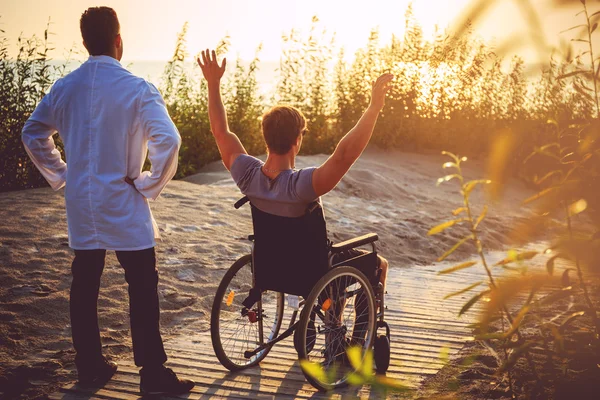 Jeune homme en fauteuil roulant et son médecin — Photo