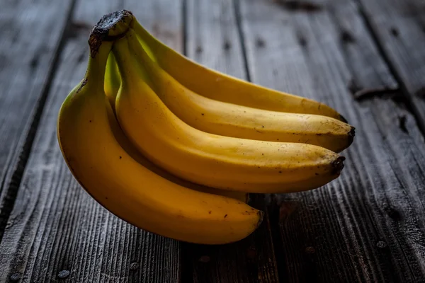 Gula bananer på ett trä skrivbord — Stockfoto