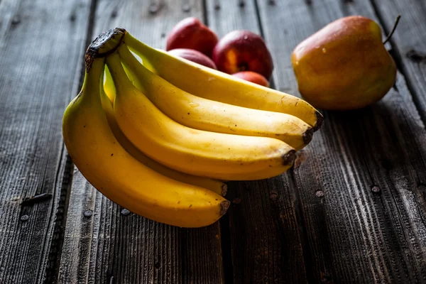 Gelbe Bananen und rote Äpfel — Stockfoto