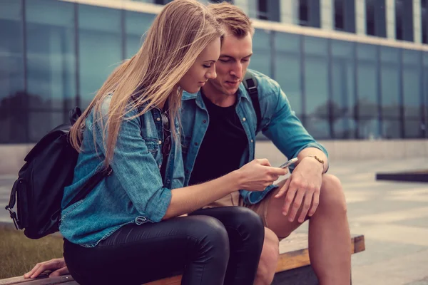 Casual young couple using smartphone — Stock Photo, Image