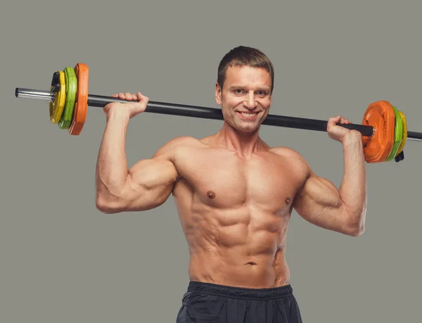 Shirtless posing with colorful barbell — Stock Photo, Image