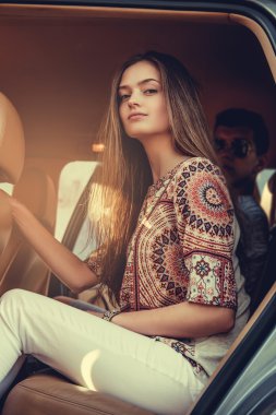 Bir arabada oturan uzun saçlı erkek