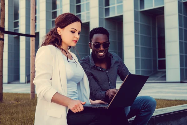 Femmina utilizzando laptop con il suo amico africano — Foto Stock