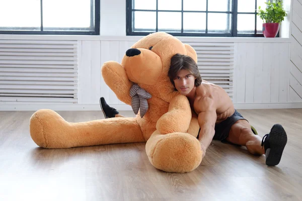 Homme posant avec un gros ours en peluche — Photo