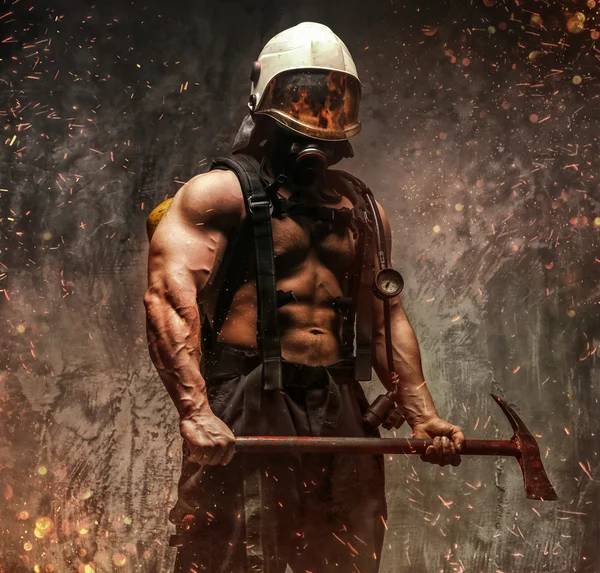 Brutale gespierde brandweerman bedrijf bijl — Stockfoto