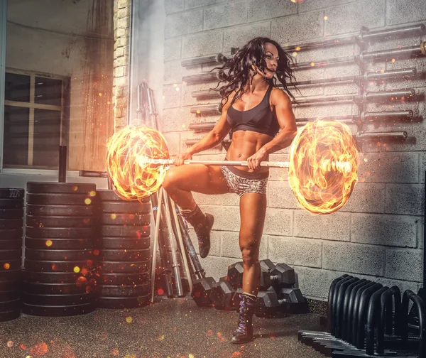 用燃烧的杠铃锻炼的女人 — 图库照片