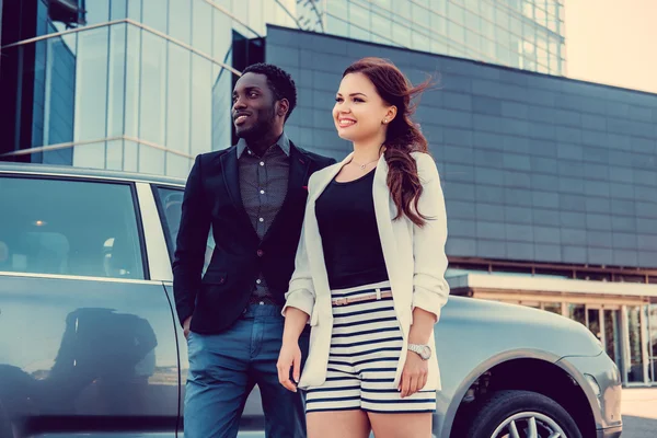 Pareja casual posando cerca de un coche — Foto de Stock